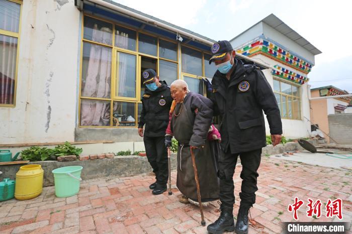 图为玉树市智慧城市管理服务中心网格员布几(右一)帮助辖区残疾老人 胡贵龙 摄
